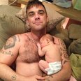 Robbie Williams holding his baby girl Teddy